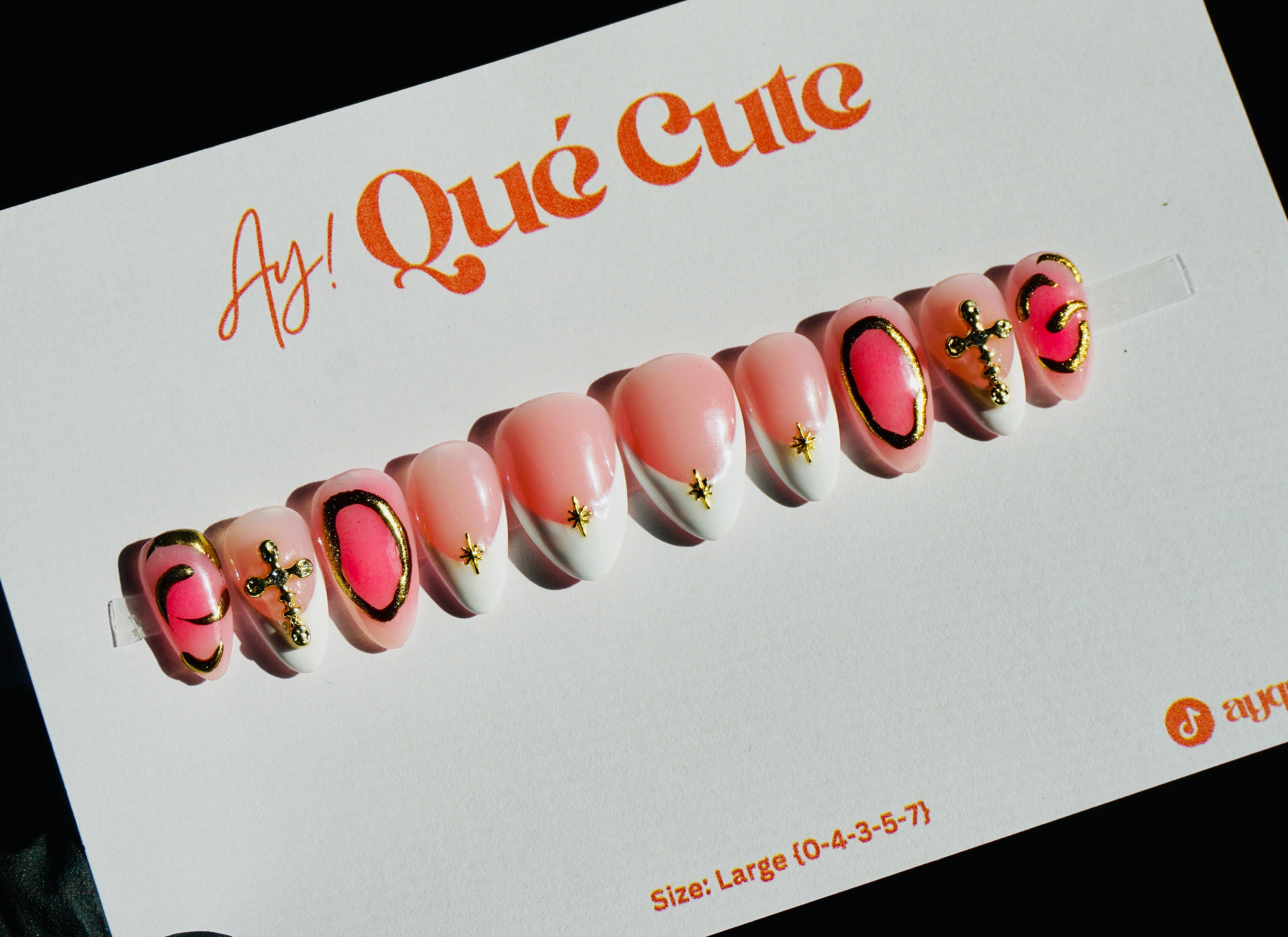 Display of false nails with 'As! Qué Cute' branding on a white card.